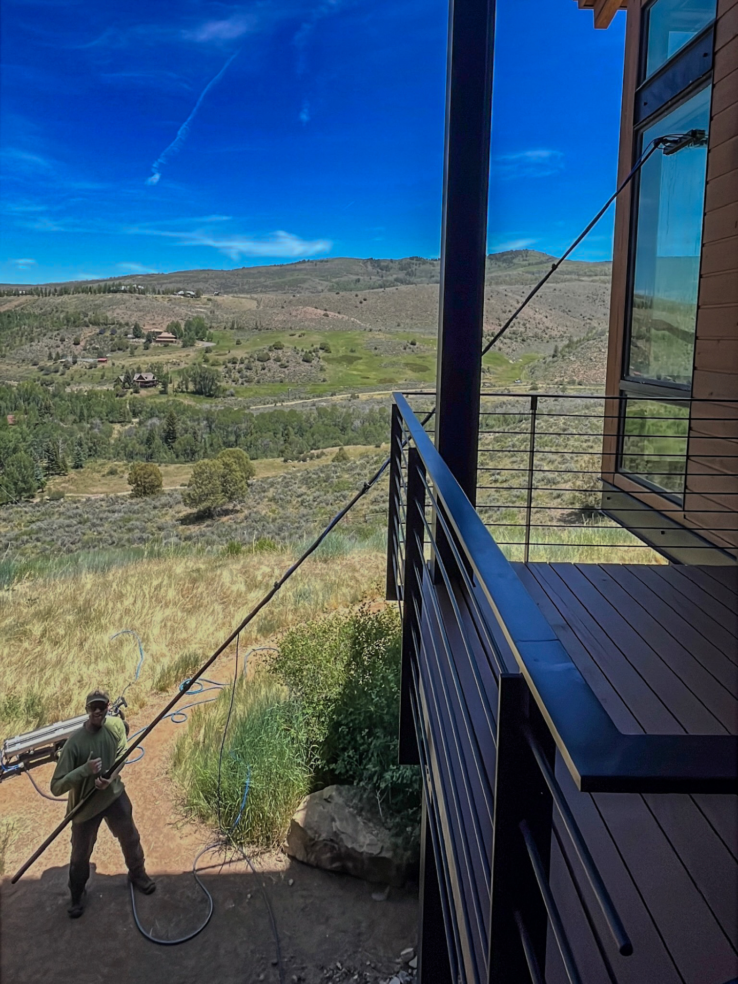 Residential window cleaning on a hillside mountain home overlooking open meadows in Lake Creek, Edwards, Colorado