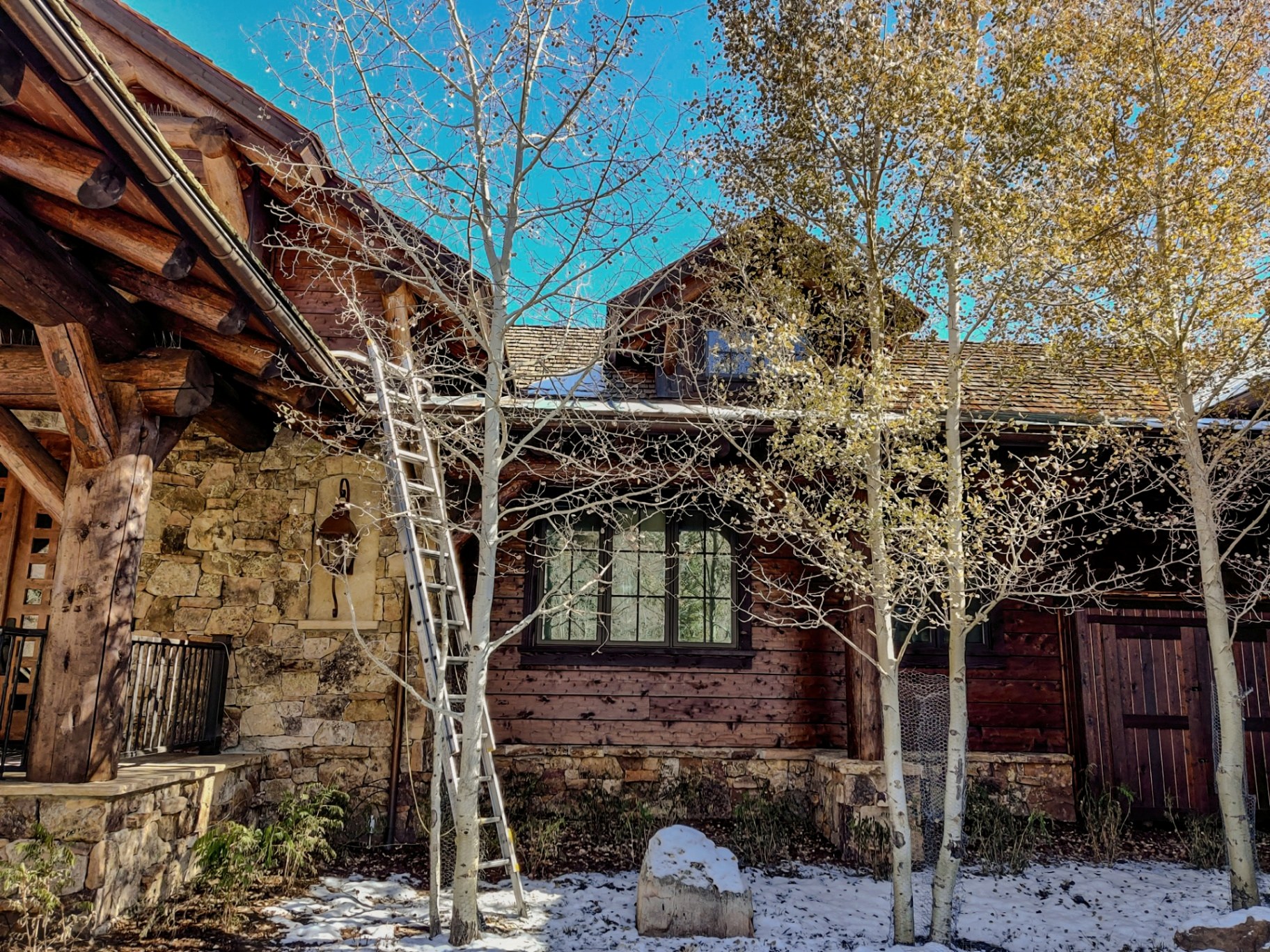 Residential window cleaning at a timber and stone custom home framed by golden aspens at Red Sky Ranch in Wolcott, Colorado