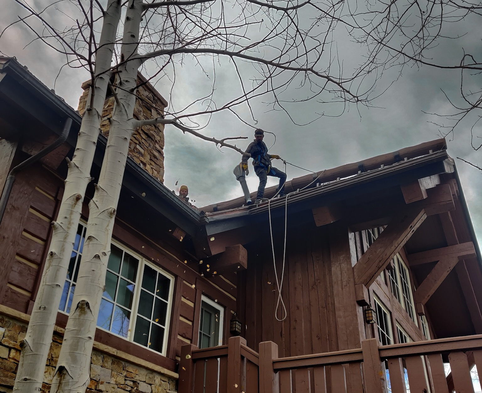 Clean Up Group gutter cleaners performing residential gutter cleaning on a mountain home in Eagle County